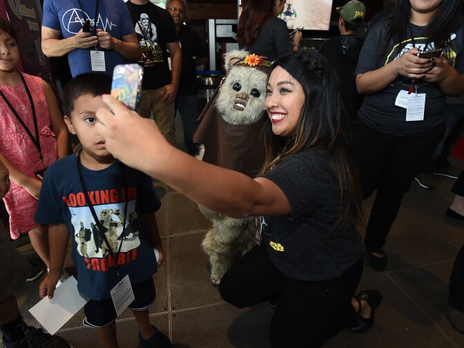 Fans take a selfie with an Ewok at a Force Friday event.
