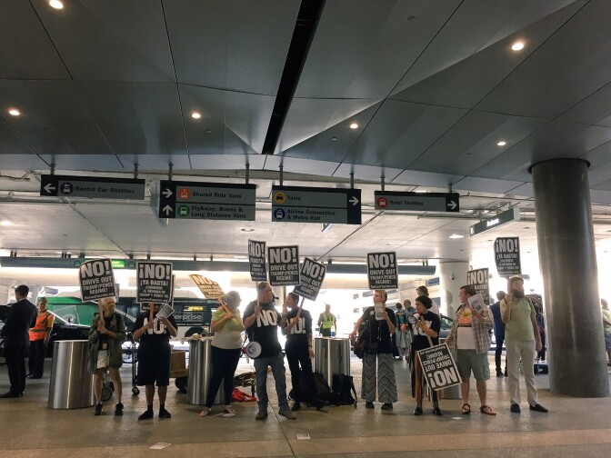 About a dozen protesters demonstrated at the overseas arrival terminal at LAX on June 29, 2017 as the Trump administration's reinstated travel ban rolls out.