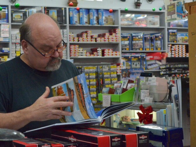 Keith Turley, a regular at The Original Whistle Stop, flips through a copy of "Milwaukee Road Locomotives."  Turley has been a model train hobbyist for 40 years and models most of his trains after the Milwaukee Road that ran across the Midwest.