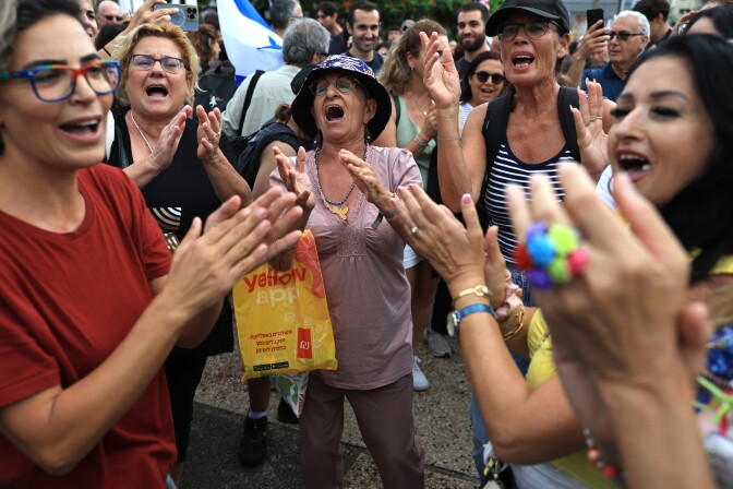 People stand in a group and clap.