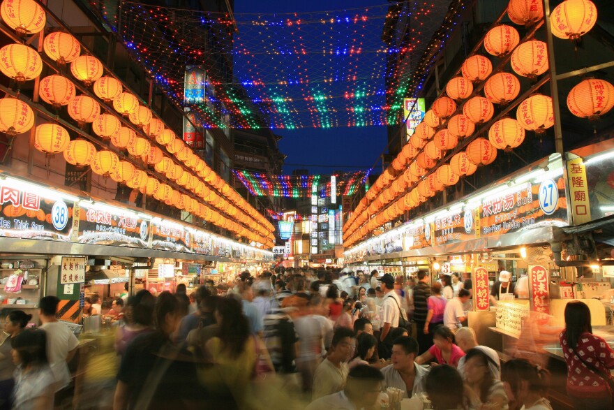 A lot of people walk around a night market in Taiwan