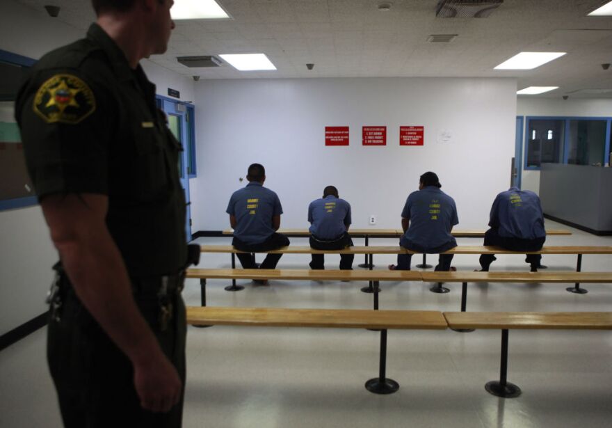 An Orange County Sheriff's deputy keeps a watch over a group of immigration detainees in the medical and dental care area at the Theo Lacy Facility in Orange, Calif., Tuesday, Sept. 28, 2010. Hundreds of detained immigrants are being transferred to Orange County jails, and more are on the way, under a deal with the federal government that would bring the cash-strapped Orange County Sheriff's Department up to $30 million a year, a newspaper reported Sunday.  