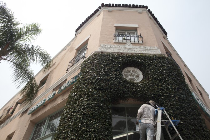 A man cleans the windows on the outside Wendell Jones' apartment in West Hollywood where he fought to keep his rent-controlled apartment.