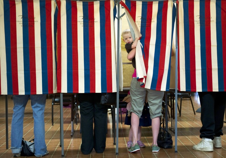 Landon Peterson peeks out of the voting booth while his mother Meghan votes March 20, 2012 at Christian union Church in Metamora, Illinois. White House hopeful Mitt Romney eyed a big win in President Barack Obama's home state Tuesday as he sought to clinch the Republican nomination and focus on November's general election. Polls across Illinois opened for the state primary at 6:00 am (1100 GMT) with former Massachusetts governor Romney the odds-on favorite to win.   AFP PHOTO/DON EMMERT (Photo credit should read DON EMMERT/AFP/Getty Images)