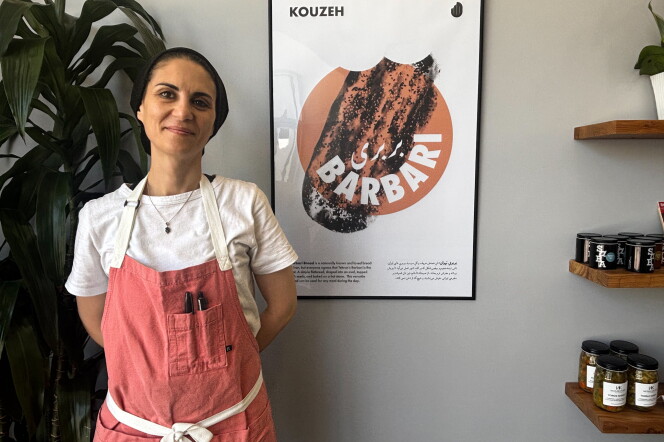 Sahar Shomali, owner of Kouzeh, stands beside a poster for barbari, the Tehran-style flatbread that inspired her to open the Mid-Wilshire bakery.