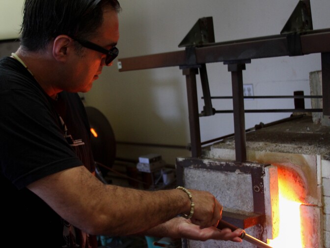 Jaime Guerrero works on a glass cup at the Watts Labor Community Action Committee building in Los Angeles on August 18, 2017.