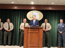L.A. City Attorney Mike Feuer (at podium) joined Sheriff Jim McDonnell (to the left of Feuer) for the news conference announcing the new guidelines for inmates convicted of gun-related crimes.