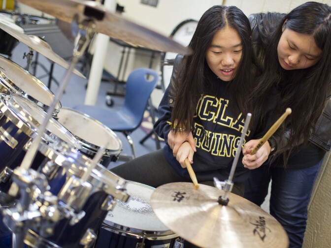 Sixteen-year-old Amber Zhang learns to play drums from freshman Ashley Li at Arroyo Pacific Academy in Arcadia on Tuesday afternoon, Nov. 17, 2015.