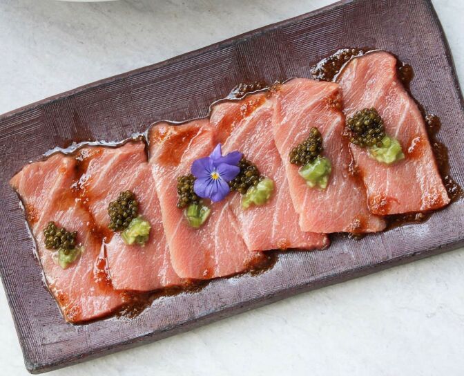 Slices of sashimi served on a clay slab. 