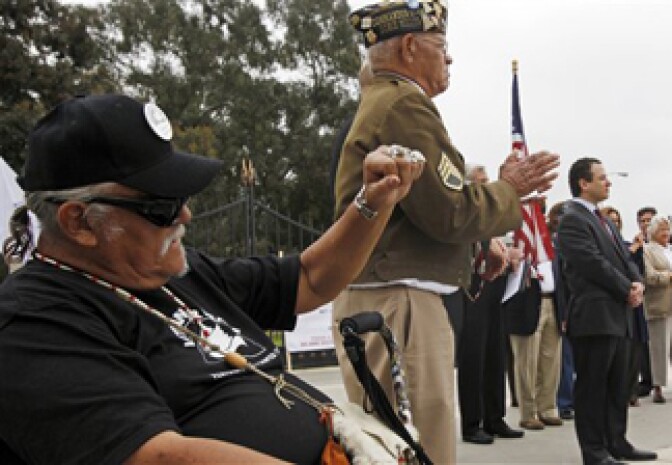 Veteran J.J. Asevedo raises a clenched fist at a news conference to announce a lawsuit against the federal government, alleging the misuse a 390-acre plot of land in West Los Angeles that was donated some 130 years ago to house veterans who need care after traumatic military experiences, at the Los Angeles Veterans Administration center in Los Angeles Wednesday, June 8, 2011. 