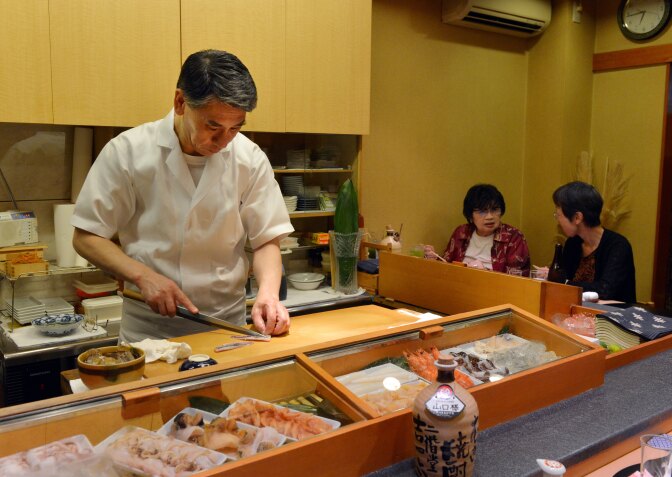 This photo taken on July 16, 2013 shows a chef and restaurant owner preparing sushi for a customer at a high-end sushi restaurant in Tokyo.