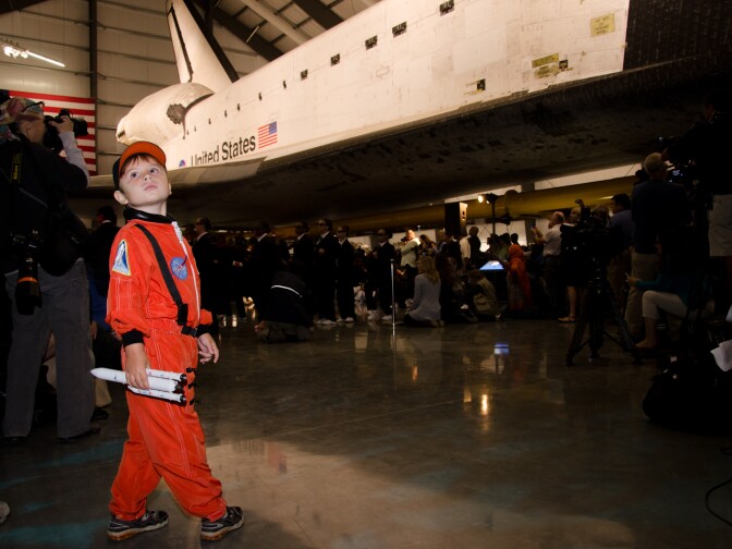 Sasha Tibelius, 4, holds a model rocket during the grand opening of the Space Shuttle Endeavour Exhibition at the California Science Center.