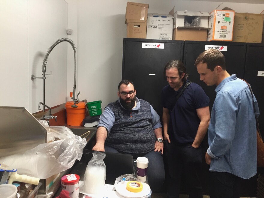 Everytable co-founders Sam Polk (middle) and David Foster (right) talk about the packing process with a chef in Everytable’s commercial kitchen in South L.A.