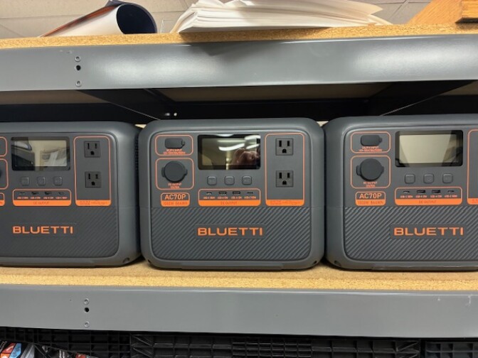 Gray portable backup power batteries on a shelf. 