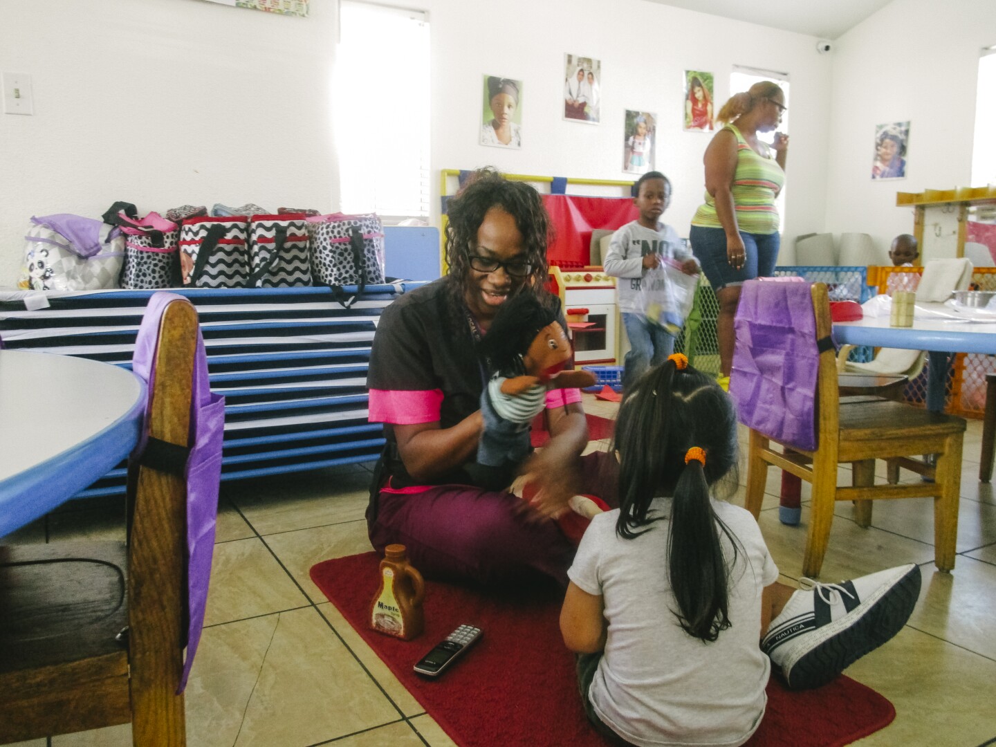 In this image, a teacher uses a hand puppet while playing with a child in the classroom.