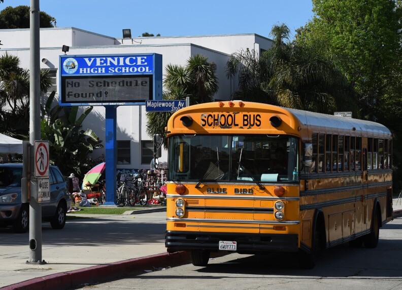 A school bus is parked outside the Venice High School, where police are investigating allegations of the sexual assault of students at the school in Venice Beach, California on March 14, 2015.  Police today are continuing their search for four male suspects who were allegedly part of a group of 14 accused of sexually assaulting two underage girls at the school.                AFP PHOTO/MARK RALSTON        (Photo credit should read MARK RALSTON/AFP/Getty Images)