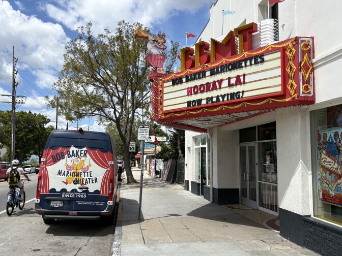 A neon theater marquee that says "IN LA TO STAY!"