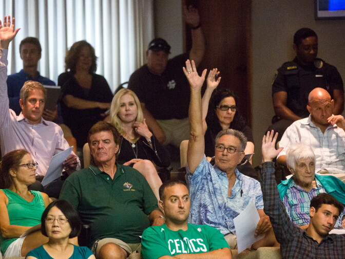 Attendees interested in taking part in public comments raise their hands during a city council meeting at Manhattan Beach City Hall on Tuesday night, July 15. The meeting was the first since a shark attack on the Manhattan Beach Pier on July 5.