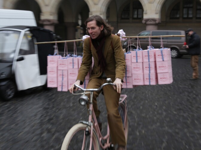 Wes Anderson going for a spin on Agatha’s pink bicycle, freighted down with Mendl’s boxes.
 