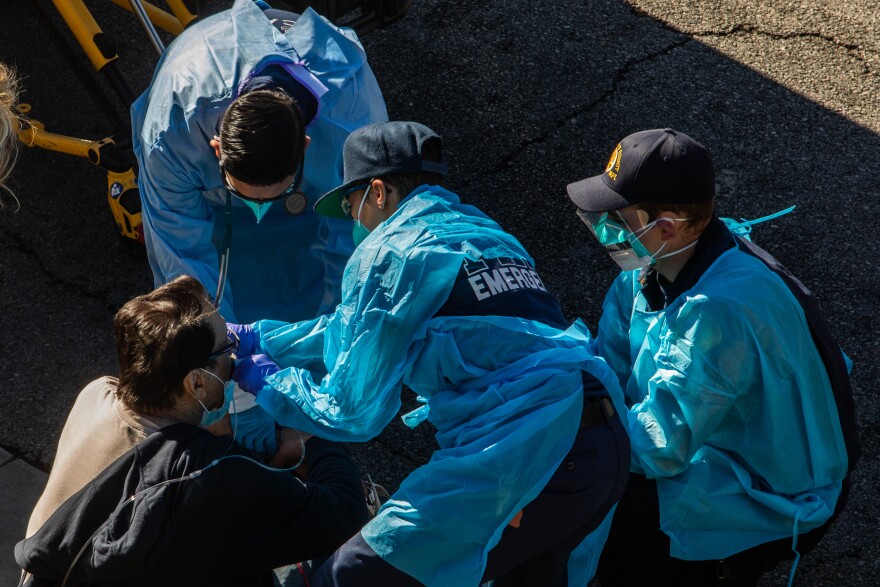County of Los Angeles paramedics administer oxygen to a potential Covid-19 patient on the sidewalk before taking him to a hospital in Hawthorne, California on December 29, 2020. - The new variant of coronavirus was detected for the first time today in the United States and Latin America as President-elect Joe Biden vowed to significantly ramp up the vaccination drive. The coronavirus has killed at least 1,775,272 people since the outbreak emerged in China in December 2019, according to an AFP tally on December 29 based on official sources. The United States is the worst-affected country with 334,967 deaths, followed by Brazil with 191,570. (Photo by Apu GOMES / AFP) (Photo by APU GOMES/AFP via Getty Images)