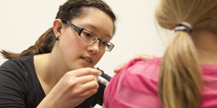 A nursing student gives a young girl a flu shot. Should non-vaccinating parents be liable if other children get sick?