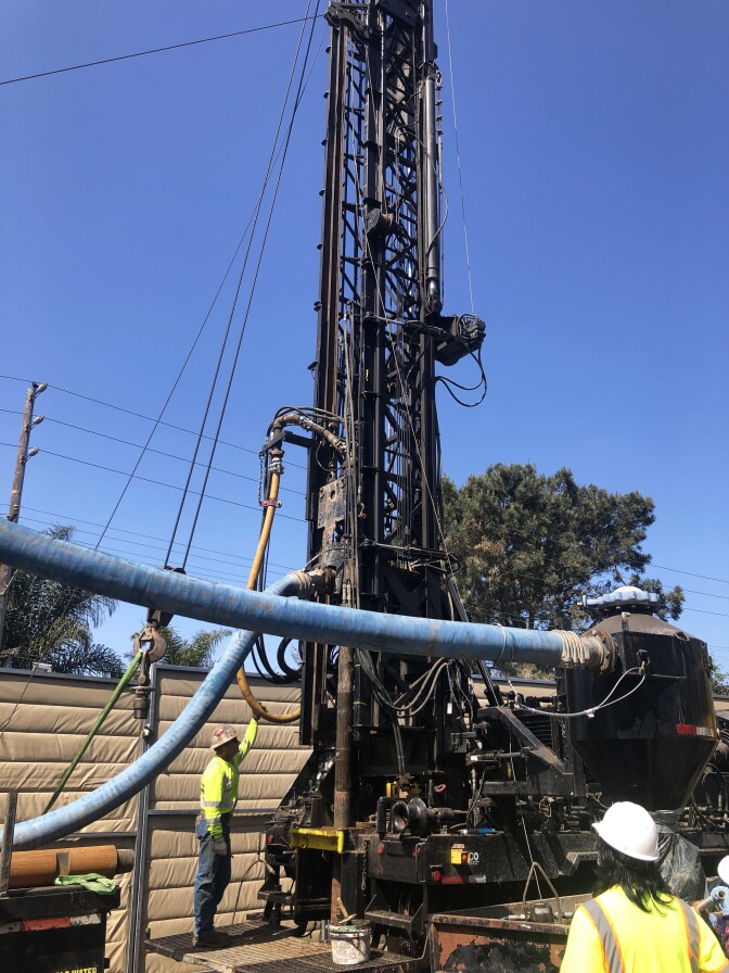 Two people standing around big machinery.
