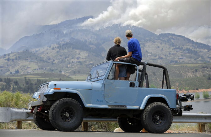 Michelle Mellenthin and Chris Huizenga watch firefighting efforts from a Jeep on June 11, 2012 near Laporte, Colorado. The High Park Fire in Larimer County has burned almost 37,000 acres and damaged or destroyed more than 100 structures. 
