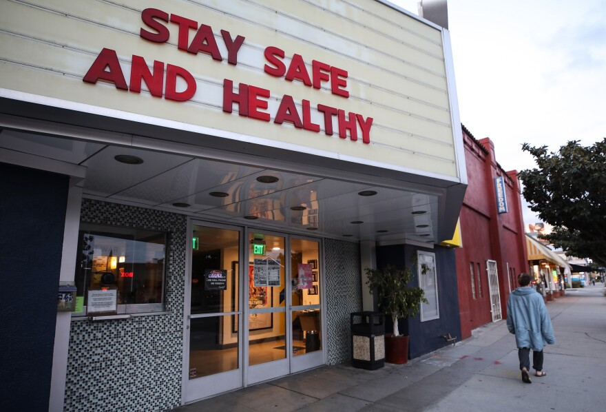 A movie theater marquee reads: "Stay safe and healthy."