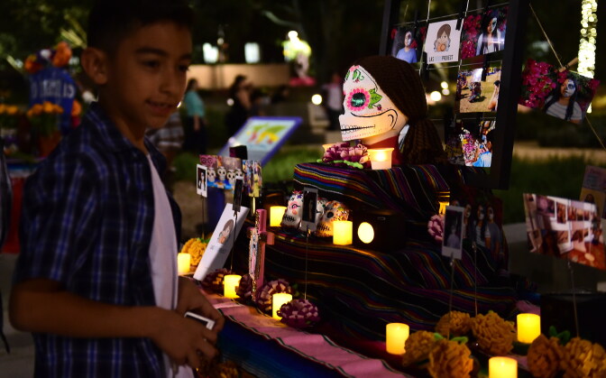 A boy views objects displayed on altars during a traditional Mexican celebration of 'Noche de Ofrenda' (Night of the Altars) in downtown Los Angeles, California on October 25, 2014, a week before the 'Day of the Dead' celebration on November 1.  AFP PHOTO / Frederic J. BROWN        (Photo credit should read FREDERIC J. BROWN/AFP/Getty Images)