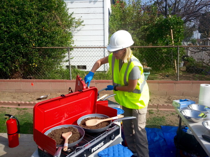 A member of an L.A. County Department of Public Health crew testing soil for lead and other toxins.