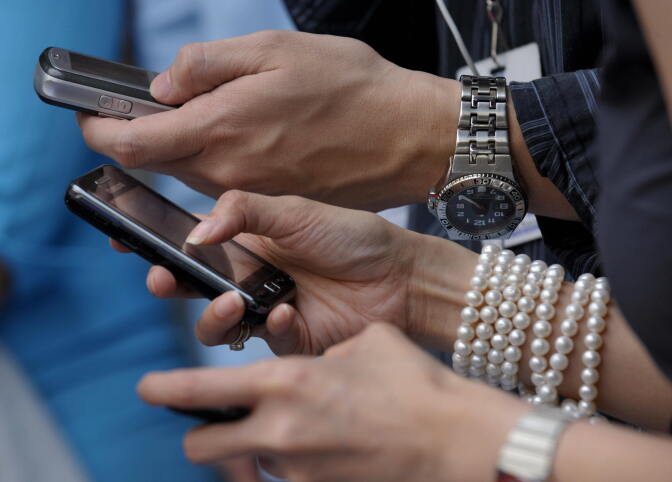 Shoppers at a mall send text messages using mobile phones September 9, 2009. Consumers in the Philippines are up in arms over a plan in Congress to impose excise tax on text and multimedia messages sent through mobile phones. With some 70 million mobile phone users and up to 300 million messages criss-crossing across mobile networks, the Philippines is widely considered as the world's texting capital.  AFP PHOTO / JAY DIRECTO (Photo credit should read JAY DIRECTO/AFP/Getty Images)
