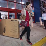 File: Black Friday shoppers carry out a flat screen tv, seen here on Thursday November 28, 2013, at a Best Buy. 
