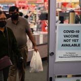 A sign on the entrance to a pharmacy reads "Covid-19 Vaccine Not Yet Available", November 23, 2020 in Burbank, California. - British drugs group AstraZeneca and the University of Oxford said they will seek regulatory approval for their coronavirus vaccine, adding to hopes that a post-pandemic economy could be in the offing following similar announcements by Pfizer/BioNTech and Moderna. (Photo by Robyn Beck / AFP) (Photo by ROBYN BECK/AFP via Getty Images)