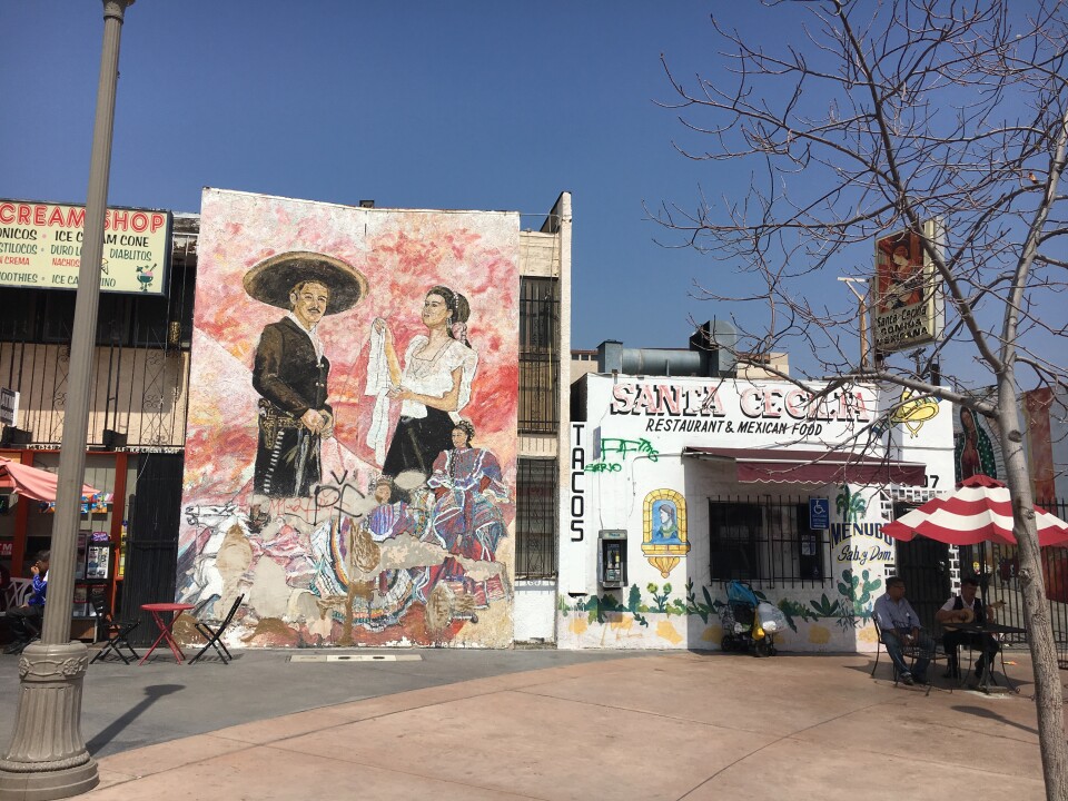 During the LA Cycle taco tour, there's a stop at Mariachi Plaza. Here you can see two Mariachis beneath the shade of an umbrella.