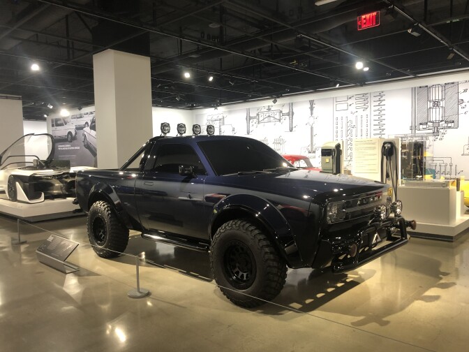 A large, dark blue truck in a museum 