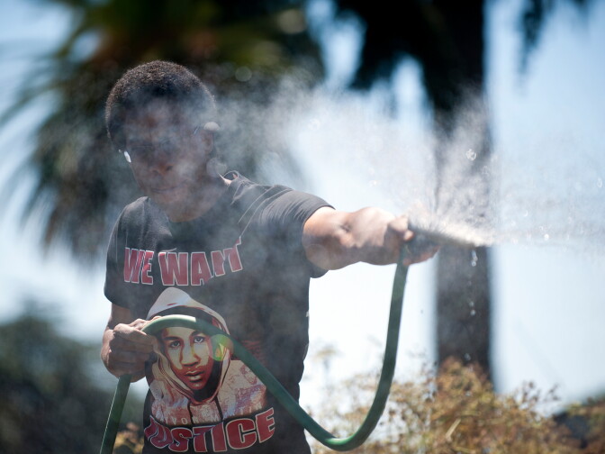 John Parker waters his garden on a hot day.