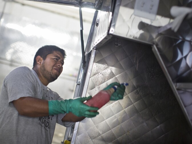 Oliver Candia of Kareem Cart Commissary and Manufacturing Co. cleans a taco cart on Wednesday morning, Sept. 2, 2015 in the company's South Los Angeles headquarters. Street cart vending is a 500 million dollar industry.