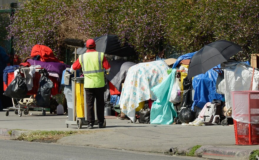 LOS ANGELES, CA - FEBRUARY 28:  A member of a clean-up crew looks at belongings of a homeless person on a public sidewalk February 28, 2013 in downtown skid row area of Los Angeles, California.  Los Angeles officials will ask U.S. Supreme Court to overturn a lower-court ruling preventing the destruction and random seizures of belongings that homeless people leave temporarily unatteneded on public sidewalks. The lower court ruling has hindered cleanup efforts.  (Photo by Kevork Djansezian/Getty Images)