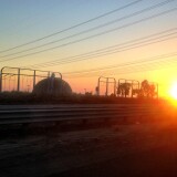 A public workshop Tuesday about safety and the storage of radioactive nuclear waste at the closed San Onofre nuclear plant is not as public as some activists would like it to be. (Photo: The sun sets behind the San Onofre Nuclear Generating Station in northern San Diego County).