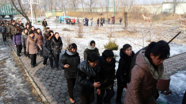 This picture taken on December 15, 2012 shows a group of North Korea workers making their way along a path after finishing work in the North Korean border town of Siniuju, across from China's northeastern city of Dandong.