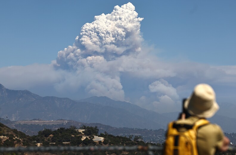 A massive plume of smoke rises over the mountains near L.A.