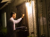 Social worker Alfred McCloud knocks on the front door of a home in south L.A. to check on a toddler. McCloud works the night shift with the Department of Child and Family Services' Emergency Response Team.