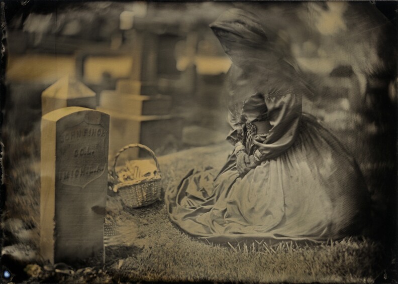 Wearing a mourning outfit complete with veil, a woman pays tribute to fallen soldiers at a Veteran’s Day memorial in San Gabriel, California. Wet plate photograph.