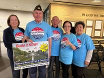 Five individuals all wearing sky blue shirts with a logo saying "Build it NOW!" — a reference to a proposed veterans cemetery in Irvine's Great Park.