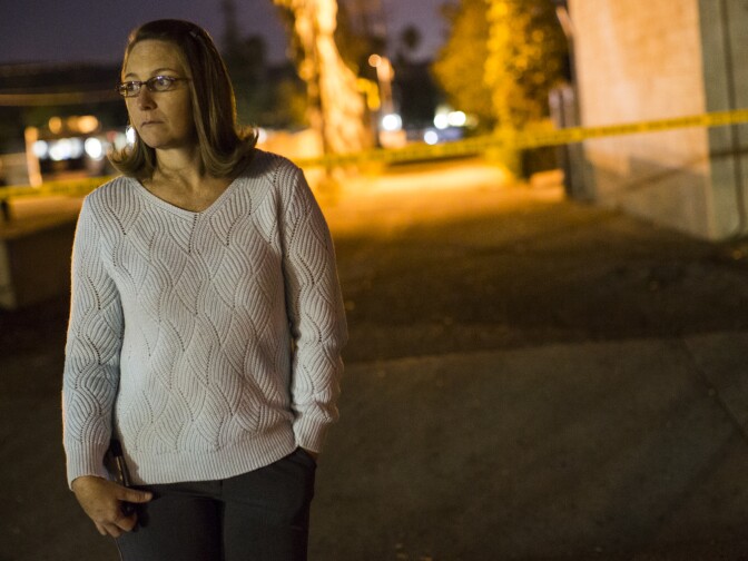 Gayle Perez, who lives on Center Street, waits near Center Street at Pine Avenue on Wednesday night, Dec. 2, 2015 as authorities serve a search warrant following a mass shooting inside the the Inland Regional Center in San Bernardino on Wednesday, Dec. 2, 2015.