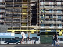 Pedestrians cross the street as construction workers work on the exterior of a commercial and residential building going up in Hollywood, California on January 22, 2014.  US housing starts dived almost 10 percent in December from a five-year high but maintained robust growth for the year as the housing market recovers,  government data showed last week, as new residential construction fell to a seasonally adjusted annual rate of 999,900 in December. The full year 2013 data underlined the strength of last year's housing market recovery following the 2006 collapse of a price bubble. AFP PHOTO/Frederic J. BROWN        (Photo credit should read FREDERIC J. BROWN/AFP/Getty Images)