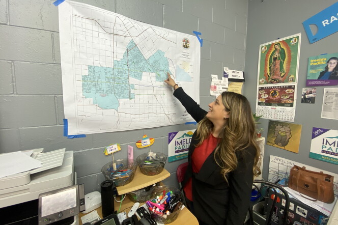Imelda Padilla, a light-skinned Latina with long brown hair falling 6-8 inches below her shoulders, points to where she lives in Sun Valley on a map on the wall of her campaign headquarters. She's weaering a dark jacket over a red blouse.