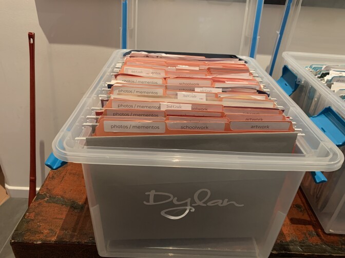 A filing box full of folders sits on a table,