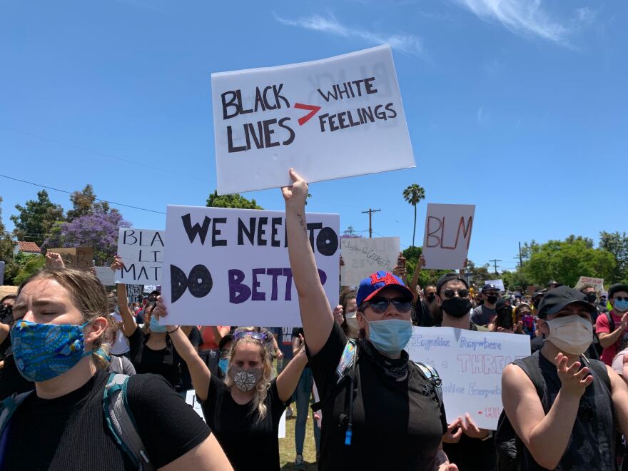White protesters holding signs supporting the Black Lives Matter movement in Los Angeles.