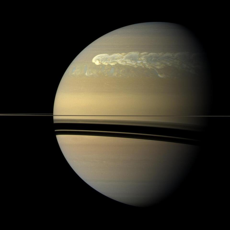 Side view of Saturn as a storm rages across its northern half.